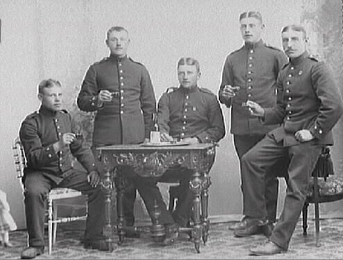 Ateljébild av fem militärer som skålar i punch.